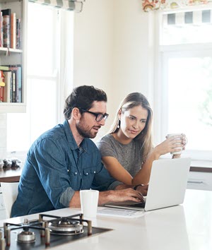 Two people reviewing a website on a laptop